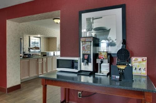 Angel Inn Central breakfast area with self serve beverage station, microwave, and buffet counter in Branson MO