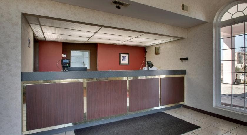 Hotel lobby front desk and reception area at Angel Inn Central in Branson, Missouri with a large arched window and check in counter