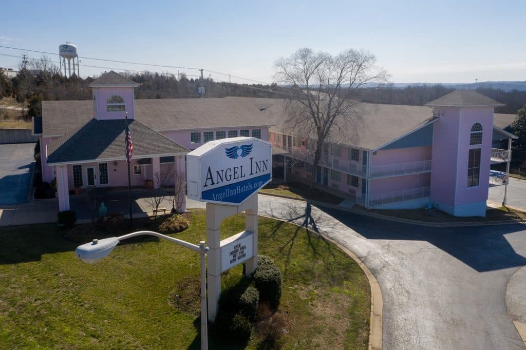 Exterior view of Angel Inn Central in Branson, Missouri, showing the hotel building and roadside sign