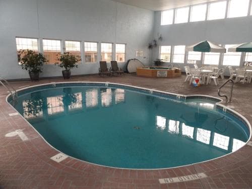 Indoor pool area at Angel Inn Central in Branson, MO with a large swimming pool, lounge seating, and bright windows