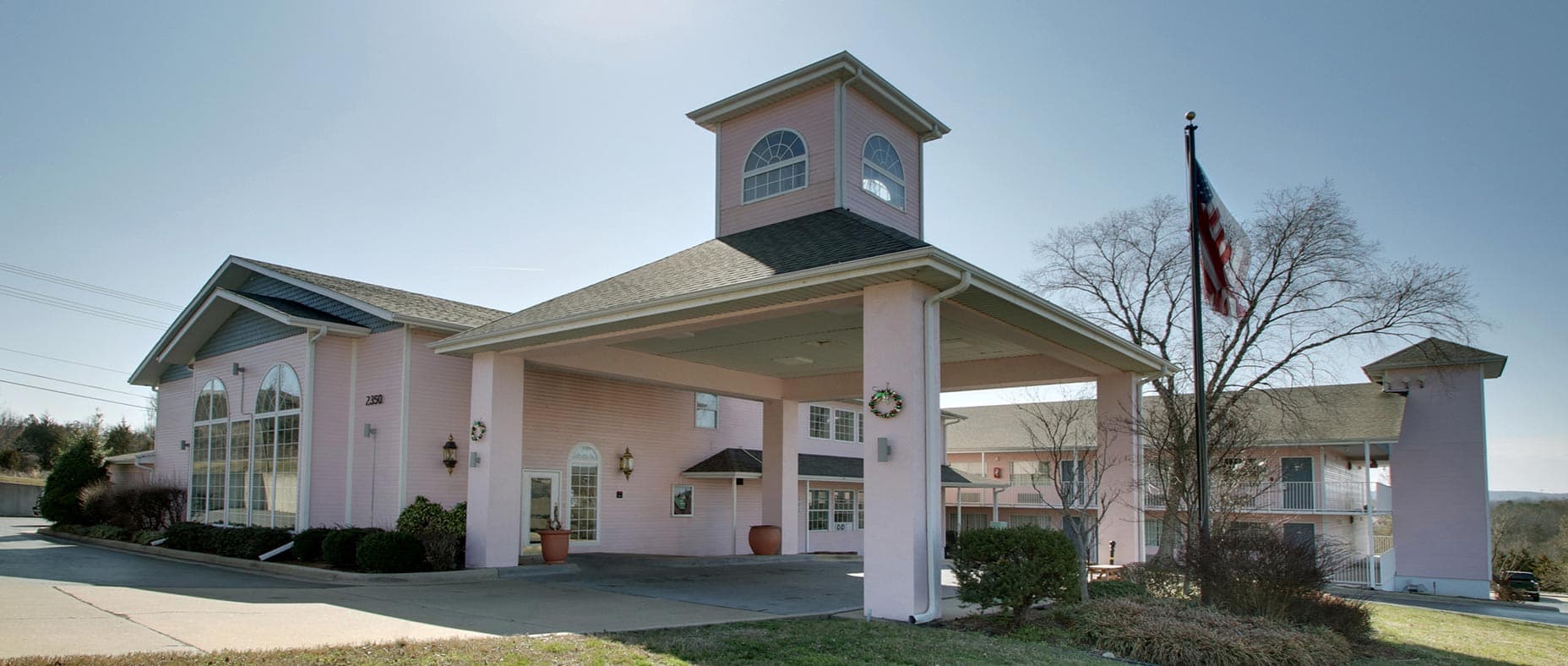Exterior view of Angel Inn Central in Branson, MO, covered entrance, driveway, and hotel facade